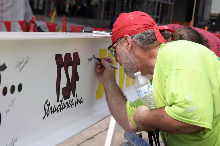Construction workers and UI leadership and staff sign a beam during construction of the Health Sciences Academic Building (HSAB) on the west side of the University of Iowa campus Wednesday, July 24, 2024.